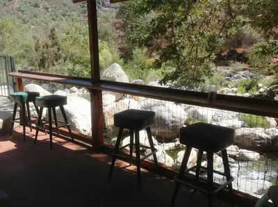 a row of stools sitting on a screened in porch at The Gateway Restaurant & Lodge in Three Rivers