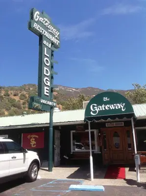 a sign for a restaurant with a car parked in front at The Gateway Restaurant & Lodge in Three Rivers