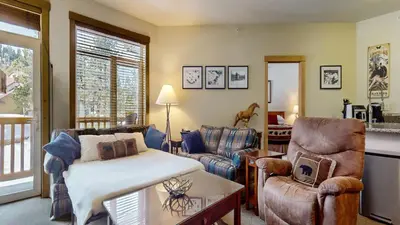 a living room with a bed and a couch and chairs at Sunstone #322 condo in Mammoth Lakes