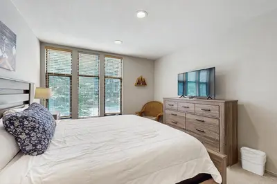 a bedroom with a bed and a dresser and windows at St. Moritz 13 in Mammoth Lakes