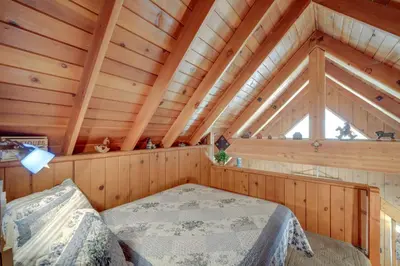 a bedroom in a log cabin with a bed and a window at Mountain Tops Ponderosa Getaway Near Dome Rock! in Ponderosa