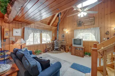 a living room with a couch and a tv at Mountain Tops Ponderosa Getaway Near Dome Rock! in Ponderosa
