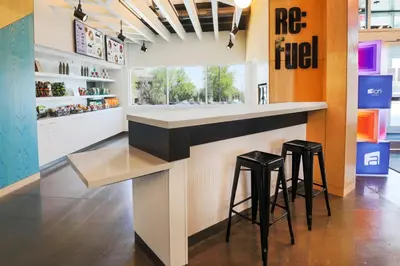 a kitchen with a counter and two stools at a bar at Aloft Reno Tahoe International Airport in Reno