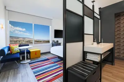 a bedroom with a bed and a sink and a mirror at Aloft Reno Tahoe International Airport in Reno
