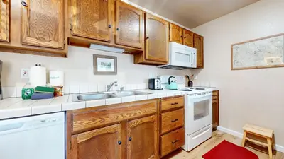 a kitchen with wooden cabinets and white appliances at Hidden Valley #107 condo in Mammoth Lakes