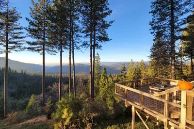 a tree house with a deck in the woods at Near Hiking Home with Deck in Twain Harte! in Twain Harte