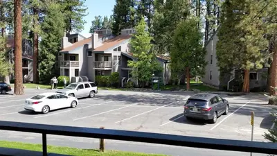 a parking lot with cars parked in front of a house at Lakeland Village #105 in South Lake Tahoe