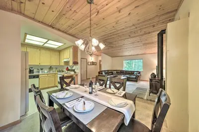 a kitchen and dining room with a table and chairs at 4 Mi to Big Tree State Park Serene Cabin with Deck in Arnold