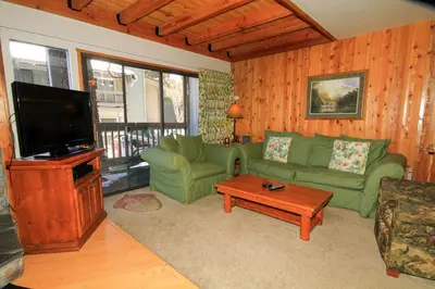 a living room with a green couch and a flat screen tv at Sierra Park Villas 23 in Mammoth Lakes