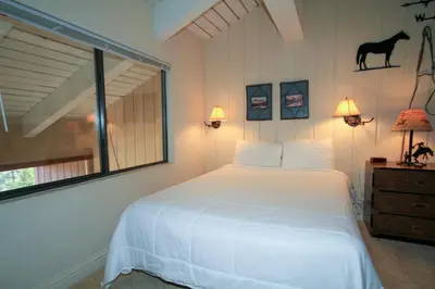 a bedroom with a white bed and a horse on the wall at Sierra Park Villas #67 in Mammoth Lakes