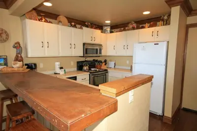a kitchen with white cabinets and a white refrigerator at Sierra Park Villas #67 in Mammoth Lakes