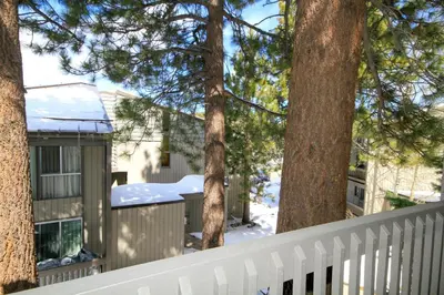 a white fence in front of a house with trees at SIerra Park Villas #06 in Mammoth Lakes
