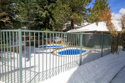 a fence in the snow with two dogs in it at Sierra Park Villas 24 in Mammoth Lakes