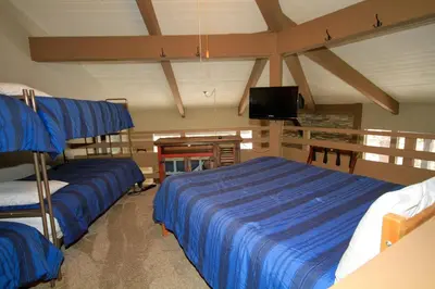 a bedroom with two beds and a flat screen tv at Sierra Park Villas 03 in Mammoth Lakes