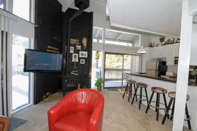 a living room with a red chair and a kitchen at Sierra Park Villas 89 in Mammoth Lakes