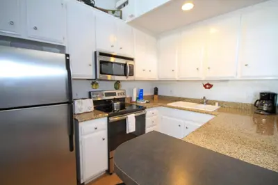 a kitchen with white cabinets and a stainless steel refrigerator at Sierra Park Villas 89 in Mammoth Lakes