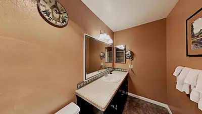 a bathroom with a sink and a clock on the wall at Comfy 2-Bedroom Home with Pool in Mammoth Lakes