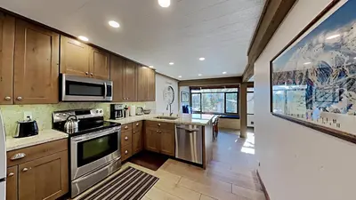 a kitchen with stainless steel appliances and wooden cabinets at Remodeled 2 Bedroom Condo with Amazing Views! in Mammoth Lakes