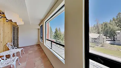 a balcony with a bench and a large window at Beautiful 2 Bedroom Condo with Mountain View! in Mammoth Lakes