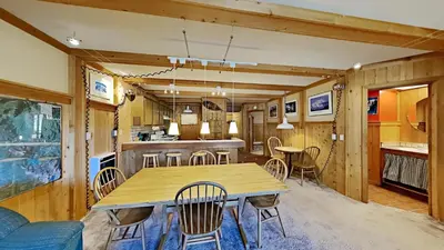 a dining room and kitchen with a wooden table and chairs at Beautiful 2 Bedroom Condo with Mountain View! in Mammoth Lakes