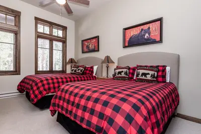 two beds in a bedroom with red and black plaid at Woodwinds 22 in Mammoth Lakes