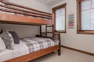 a bedroom with two bunk beds and two windows at Woodwinds 22 in Mammoth Lakes