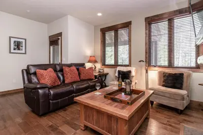 a living room with a leather couch and a table at Woodwinds 22 in Mammoth Lakes