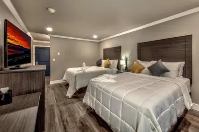 a hotel room with two beds and a flat screen tv at The Elet Hotel in South Lake Tahoe