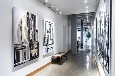 a hallway with black and white pictures on the walls at Tapestry By Hilton The Fort Sutter Hotel Sacramento, Ca in Sacramento