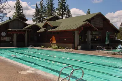 a house with a swimming pool in front of a building at Tahoe Donner Retreat with Decks and Lake Access! in Truckee