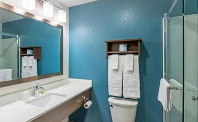 a bathroom with a toilet and a sink and a mirror at WoodSpring Suites Reno Sparks in Sparks
