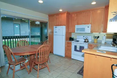 a kitchen with a wooden table and a white refrigerator at Sierra Park Villas 20 in Mammoth Lakes