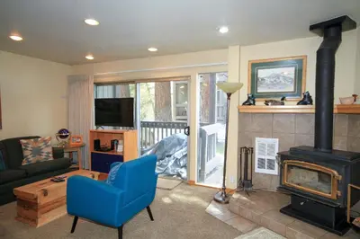 a living room with a blue chair and a fireplace at Sierra Park Villas 20 in Mammoth Lakes