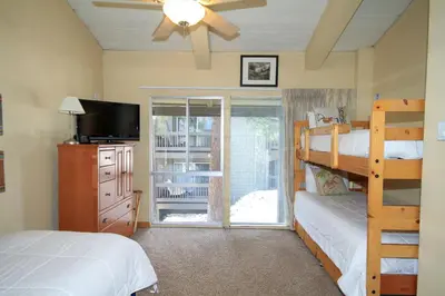 a bedroom with two bunk beds and a sliding glass door at Sierra Park Villas 20 in Mammoth Lakes