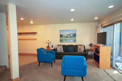 a living room with a couch and blue chairs at Sierra Park Villas 20 in Mammoth Lakes