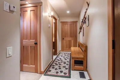 a hallway with a wooden door and a rug at Northstar - Ski View Condo in Truckee