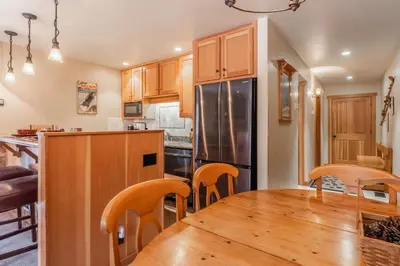 a kitchen with a wooden table and a refrigerator at Northstar - Ski View Condo in Truckee