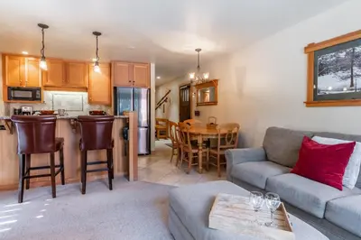 a living room with a couch and a kitchen at Northstar - Ski View Condo in Truckee