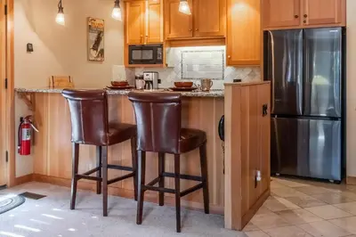 a kitchen with a refrigerator and two bar stools at Northstar - Ski View Condo in Truckee
