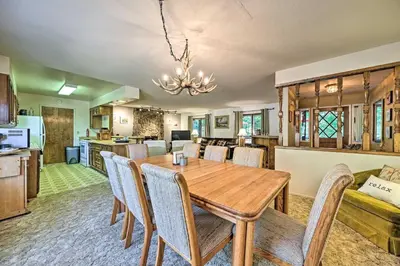 a dining room and kitchen with a wooden table and chairs at Home with Serene Deck in Twain Harte! in Twain Harte