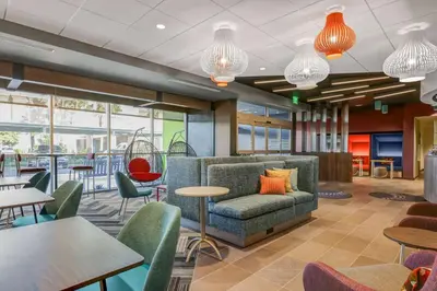 a lobby with tables and chairs and a couch at Tru By Hilton Lathrop in Lathrop