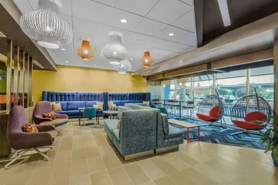 a waiting room with chairs and tables and windows at Tru By Hilton Lathrop in Lathrop
