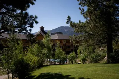 a large building with a field of grass and trees at Sunstone Lodge by 101 Great Escapes in Mammoth Lakes