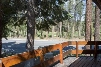 a wooden bench sitting on a deck in front of a tree at Mammoth Golf Properties By 101 Great Escapes in Mammoth Lakes
