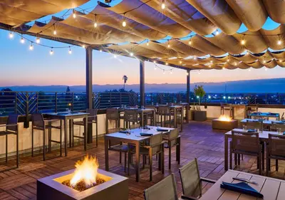 a restaurant with tables and a fire pit on a roof at The Darling in Visalia