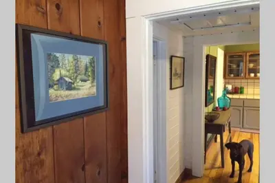 a dog standing in a hallway next to a kitchen at Vans Yosemite Garden Cottage in Groveland
