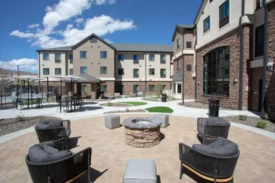 a courtyard with chairs and tables and a building at Staybridge Suites - Carson City - Tahoe Area by IHG in Carson City