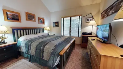 a bedroom with a bed and a flat screen tv at Hidden Valley #104 condo in Mammoth Lakes
