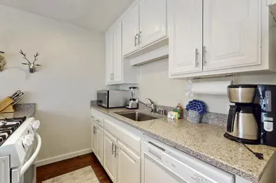 a kitchen with white cabinets and a sink at Cozy Coyote Fork Condo in Truckee
