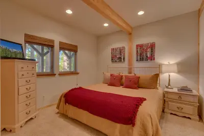 a bedroom with a bed and a dresser and windows at Northstar Conifer Luxury Home home in Truckee